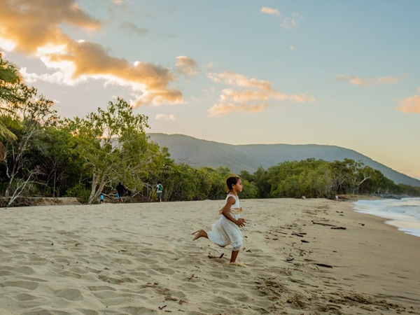 a young girl running along the beach at Kewarra Beach