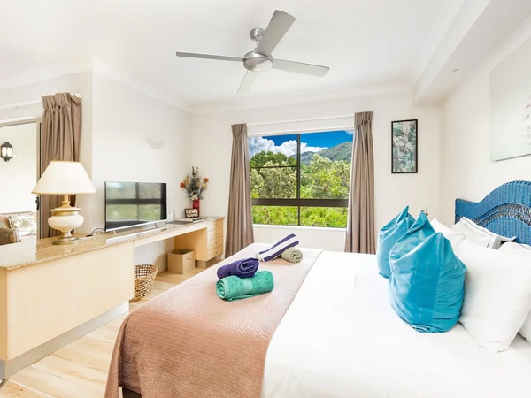 a cosy bedroom with a window at Scenic 1BR Balcony, Cairns North