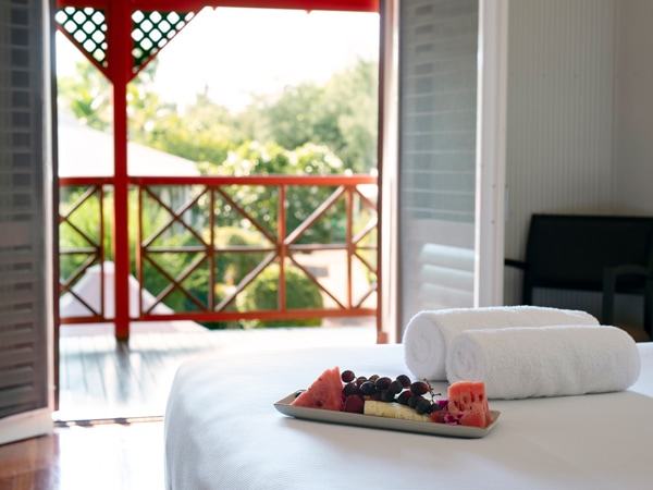 a fruit platter on the bed inside a studio-type room at Cable Beach Club Resort and Spa