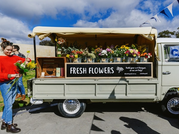 a woman holding fresh flowers at The Little Burley Market, Canberra