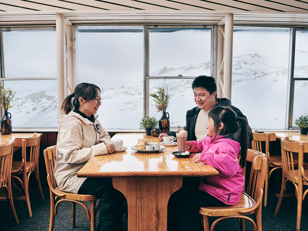 a family enjoying scones and hot chocolate at Eagles Nest Restaurant, Thredbo 
