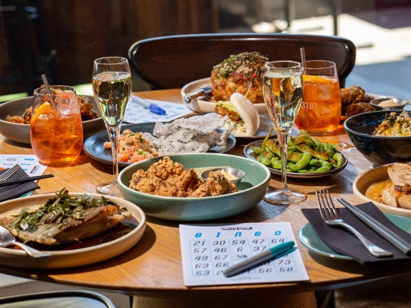 a bingo card alongside Japanese dishes at Tokyo Tina's Bingo Academy