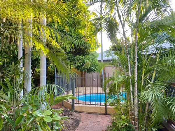 a pool framed by a tropical garden at Pindan Cable Beach, Broome
