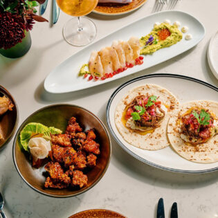 A table topped with plates of food and drinks.
