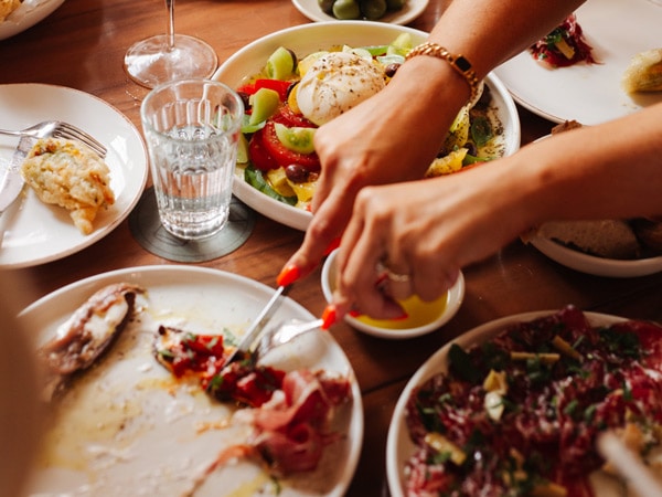 a hand slicing brunch food on the plate at Mille Vini, Sydney