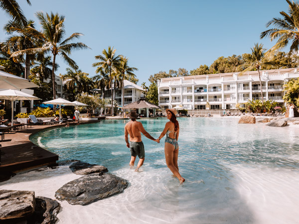a couple relaxing at the pool, Peppers Beach Club & Spa Palm Cove accommodation