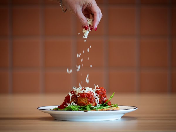 garnishing a plate at Café Sosta in Canberra