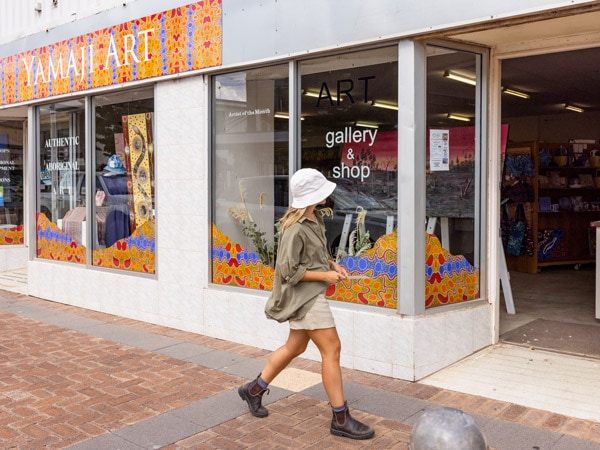 Woman walking past Yamaji Art Centre, Geraldton