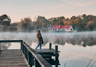 a woman standing on the edge of Lake Daylesford Bridge