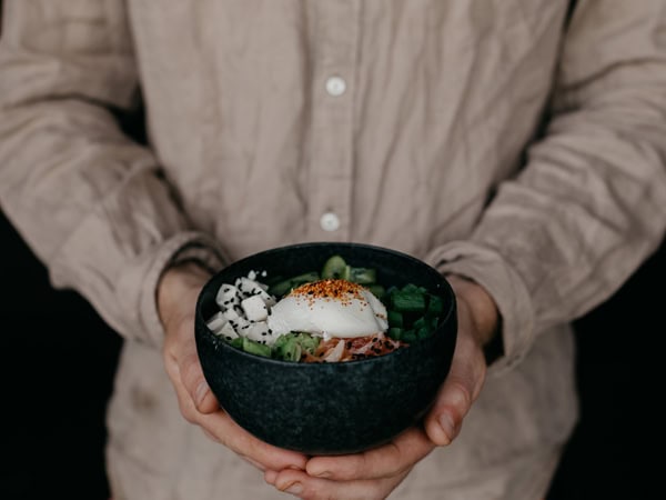 a hand holding a breakfast bowl at Intra, Canberra