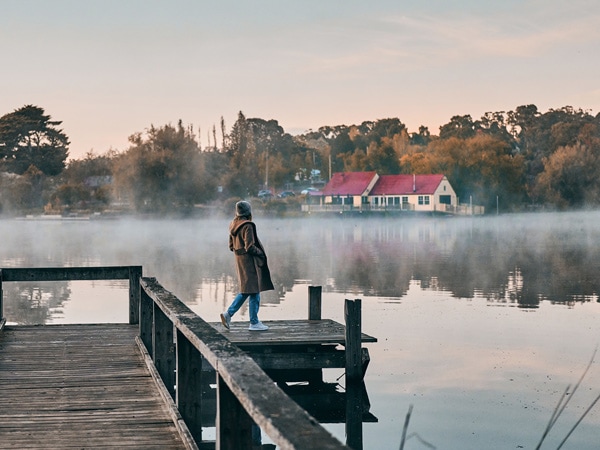 a woman standing on the Lake Daylesford Bridge