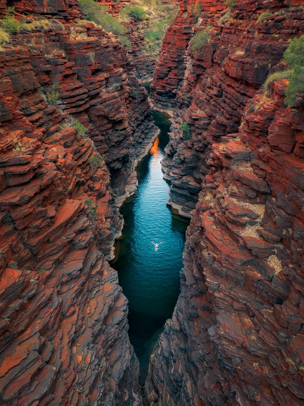 a person soaking in the swimming hole at Joffre Gorge, Karijini National Park
