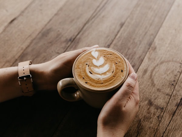 a hand holding a cup of coffee