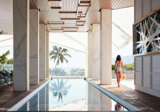 a woman walking by the pool at Crystalbrook Flynn, best accommodation in Cairns
