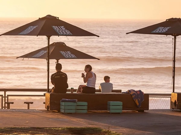 dining under beachside umbrellas at Blue Door Kiosk, Newcastle