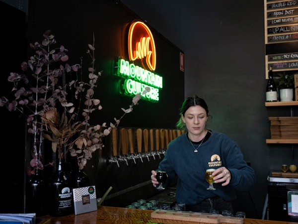 a bartender holding beer at Mountain Culture Beer Co