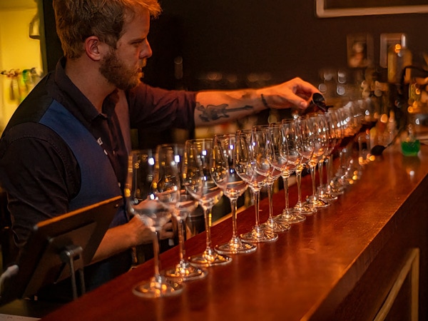 a bartender arranging wine glasses at Conservatory Bar, Cairns