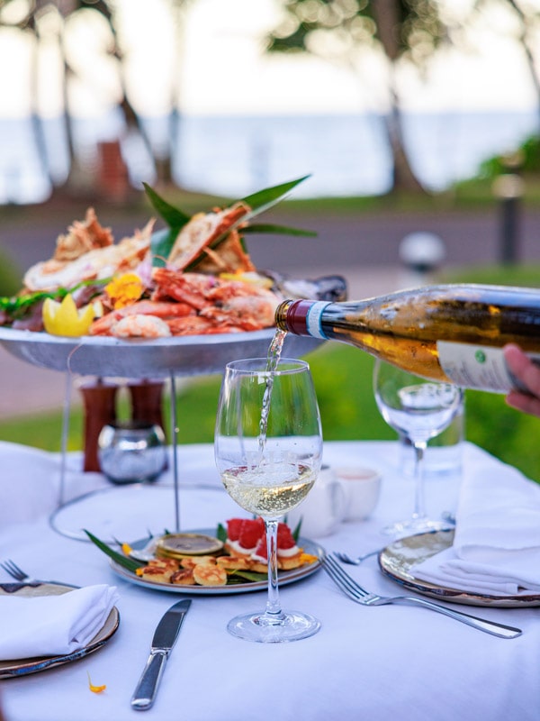 pouring wine into the glass on the table at The Reef House Boutique Hotel and Spa