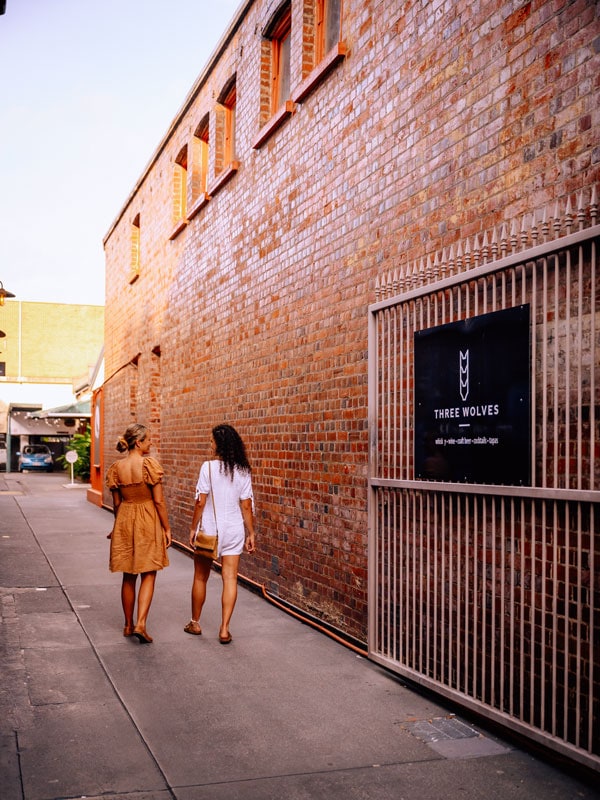 two girls walking by the side of Three Wolves, Cairns