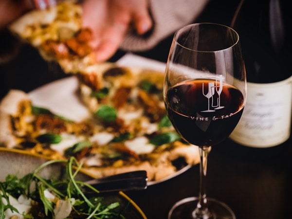 a glass of wine with pizza on the side at Vine & Tap Wine Bar, Bathurst
