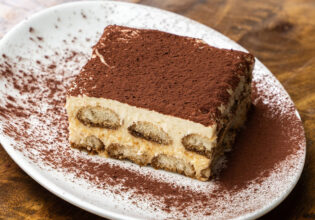 A piece of tiramisu on a white plate.