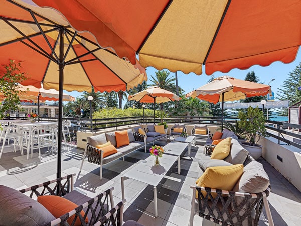 a cosy al fresco seating area with orange umbrellas at Balcony Bar, Sydney, NSW