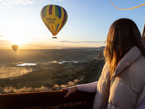 A girl looks out over the Hunter Valley during a ballon flight with Balloon Aloft