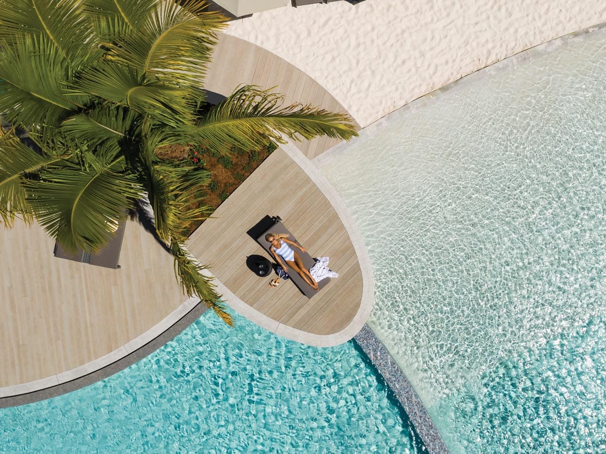 an aerial view of a woman relaxing by the pool at Crystalbrook Riley, Cairns