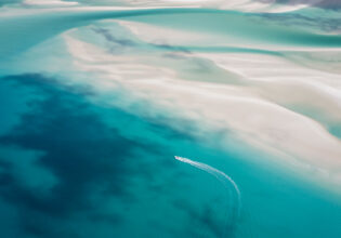 Aerial view of a boat cruising through the Whitsundays