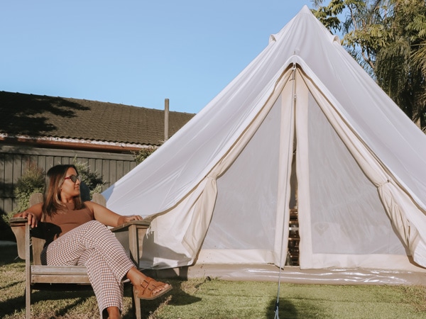 a woman sitting outside a glamping tent at The Hideaway Cabarita Beach