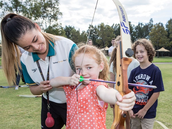 a kid learning how to shoot arrows at the Sydney Olympic Park Archery Centre