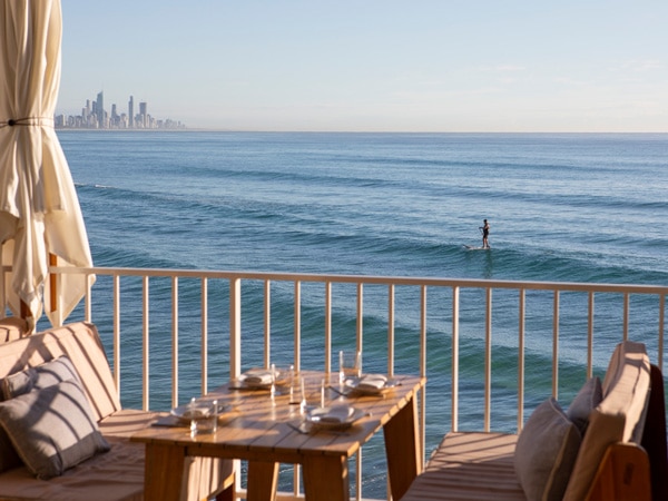 a surfer seen from the waterfront dining at Burleigh Pavilion