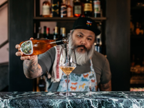 a bartender pouring wine into the glass at Mille Vini Wine Bar & Restaurant, Surry Hills