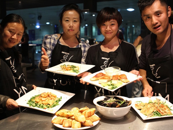 students holding their dishes at Cooking class at the Sydney seafood school