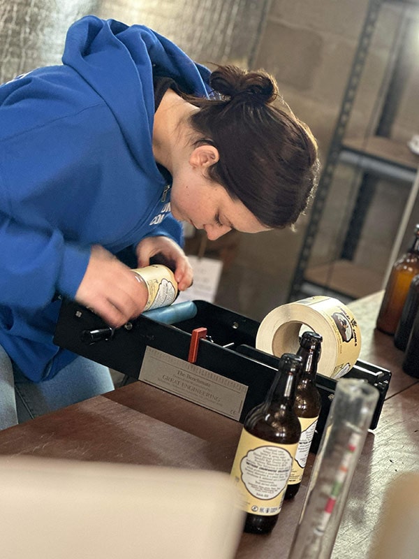 labels being put on bottles at 2Wild Souls Meadery