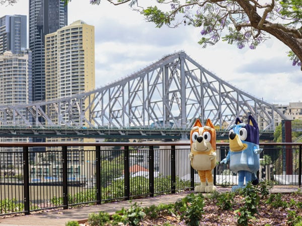 Bluey and Bingo in front of Story Bridge in Brisbane