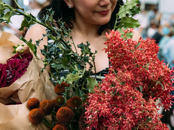 a close-up of a woman holding flowers at Carriageworks Market