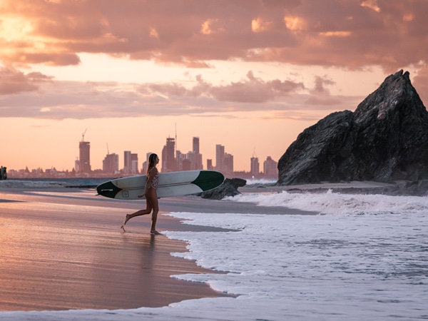 a woman heading to surf in Gold Coast, Qld