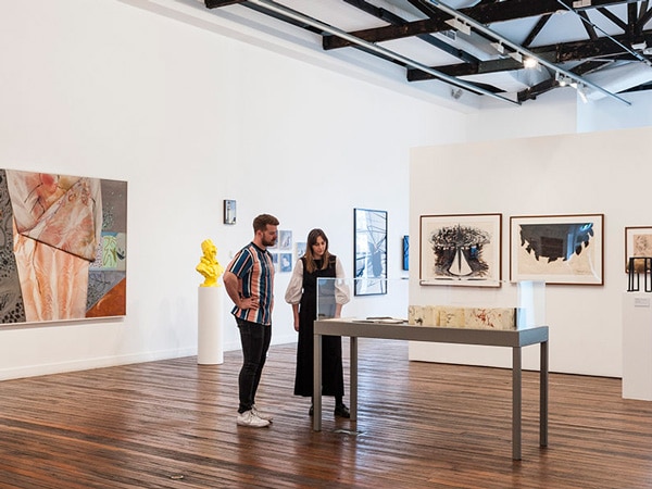 two people admiring artworks at NAS Galleries