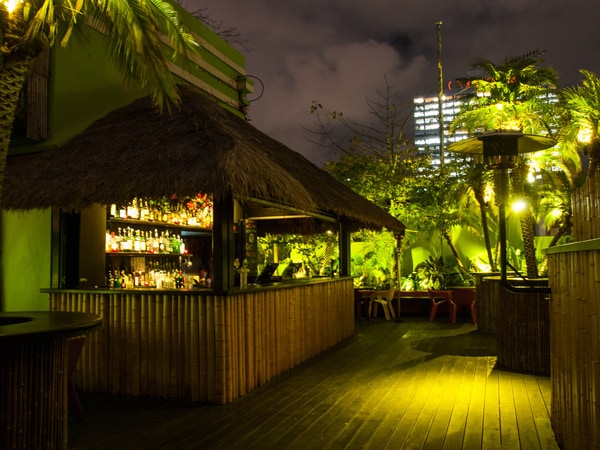 the bamboo Tiki bar with green lighting at Palmz Rooftop Bar, Melbourne CBD