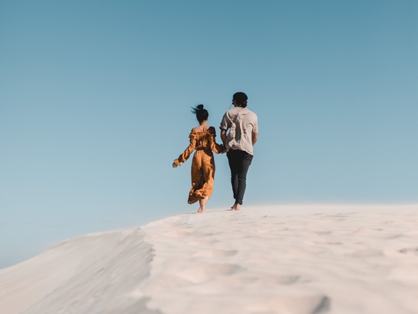 a couple walking along the white sand at Robe, SA