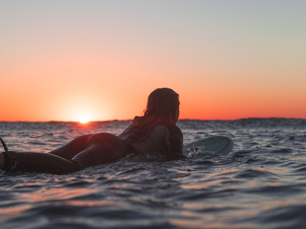 surfing in Southport Beach at sunset