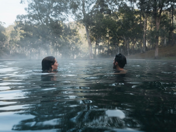 a couple soaking a dip in the Yarrangobilly Caves Thermal Pool, Yarrangobilly, NSW