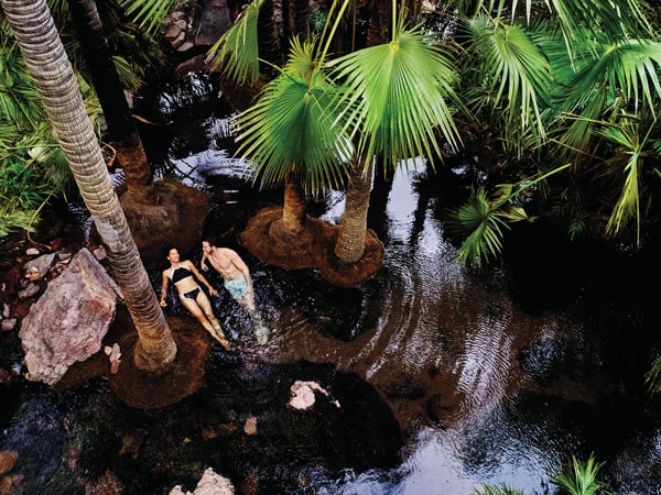 a couple enjoying a swim at Zebedee Springs, El Questro Wilderness Park, WA