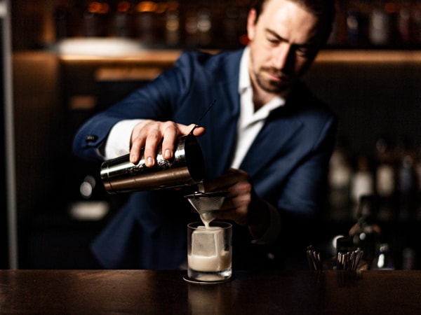 a bartender preparing a drink at Bar Besuto