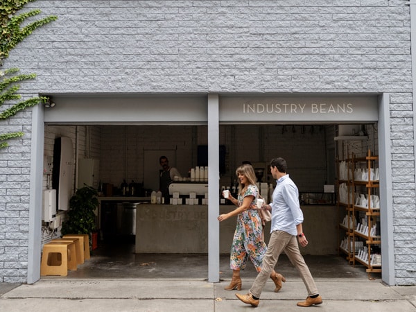 two people walking on the side of Industry Beans, Fitzroy