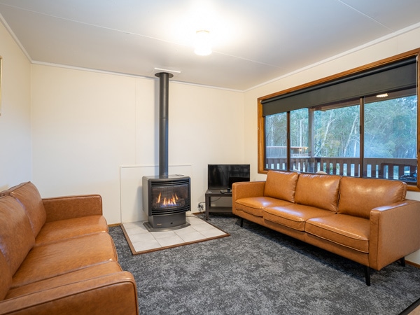 a lounge with a fireplace at Binda Bush Cabins, Jenolan Caves, Blue Mountains