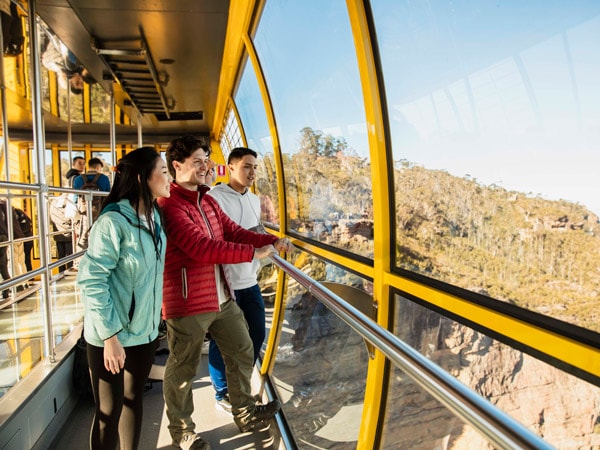 young people enjoying the views of the Blue Mountains from the Skyway at Scenic World
