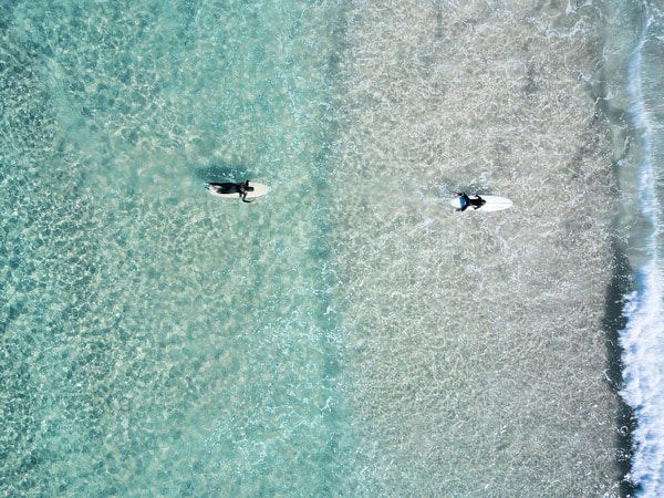 a drone shot of people surfing in The Pass, Byron Bay