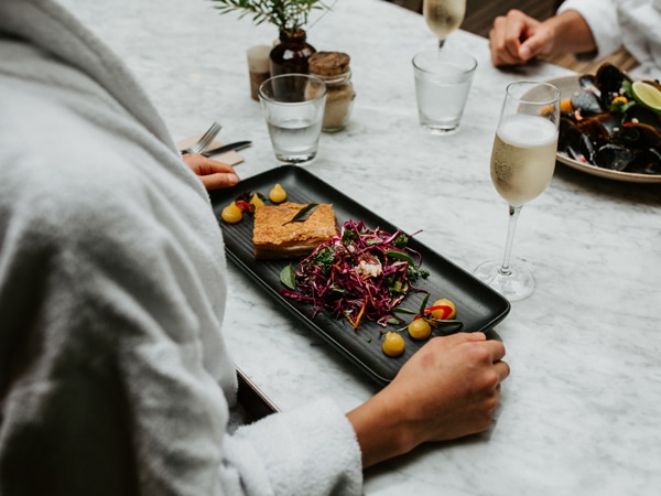 holding a tray of food on the table at Spa Dreaming Centre